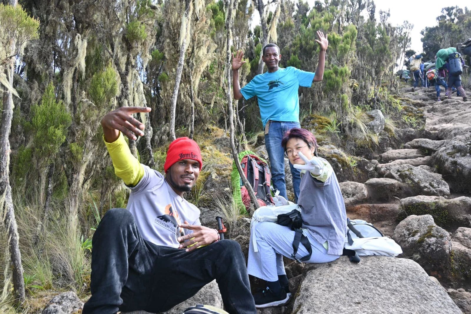 Guides and climbers resting on a forested Kilimanjaro trail