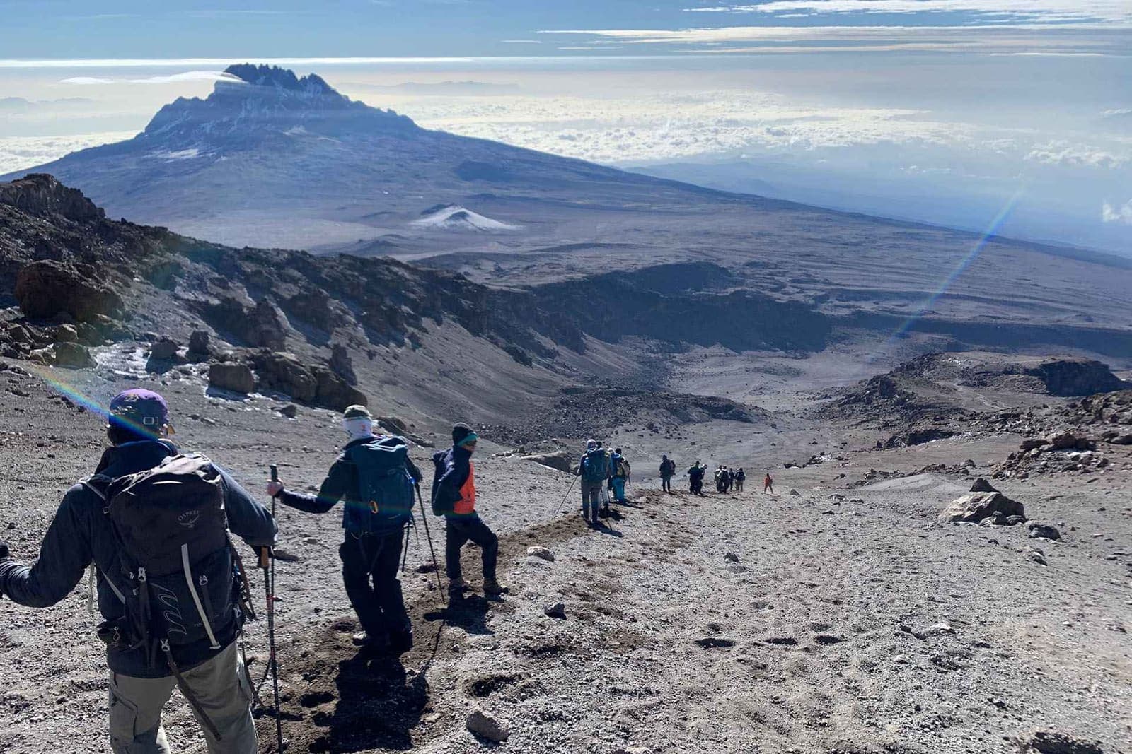 Hikers crossing a high rocky slope on Mount Kilimanjaro
